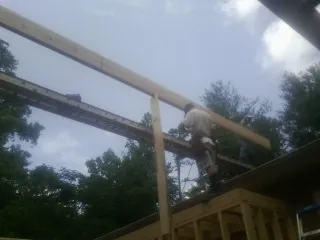 Carpenter setting a ridge beam over a new addition frame — Ice Dam Removal by Roofing Brothers in Brown City