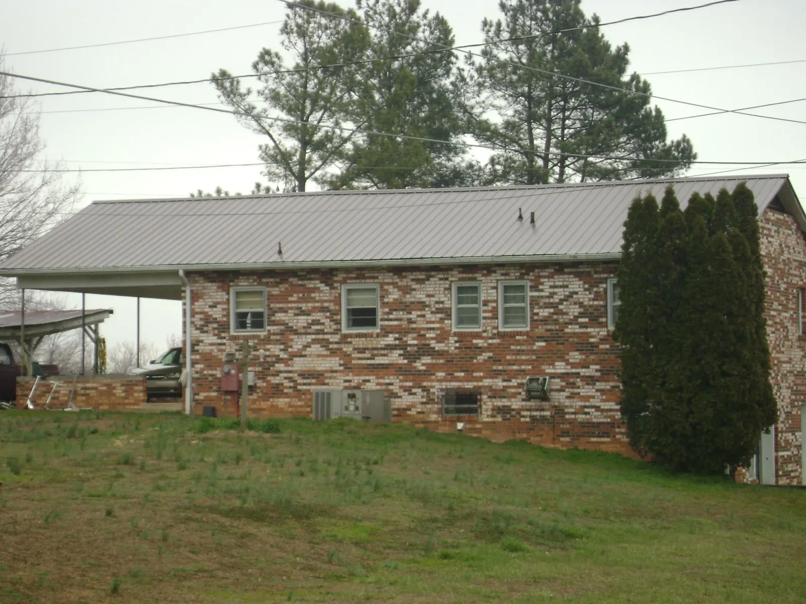 Gray metal roof on a brick split level home with a carport in Brown City