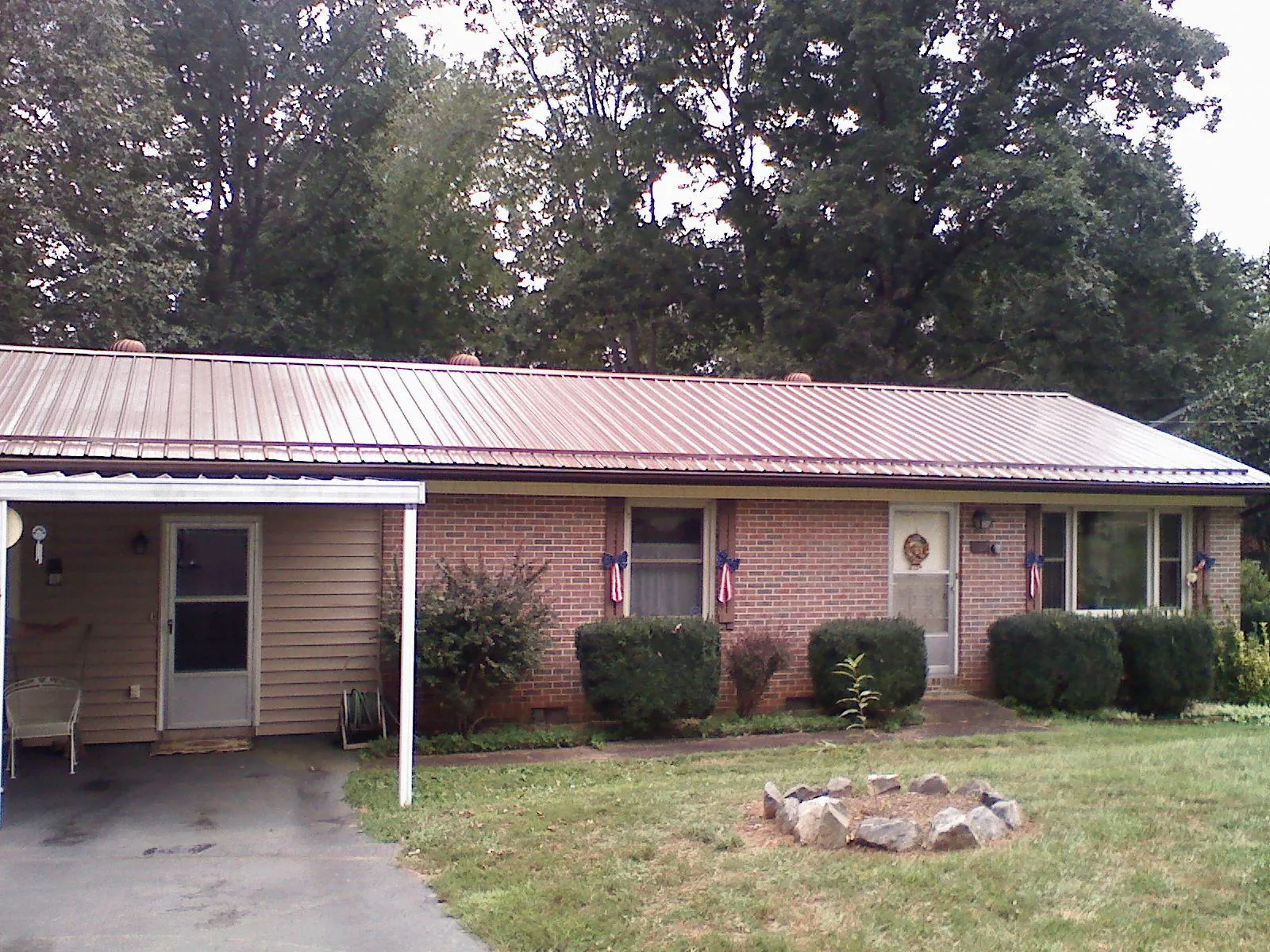 Bronze metal roof and carport on a brick ranch home — Roof Repair work by our crew in Brown City