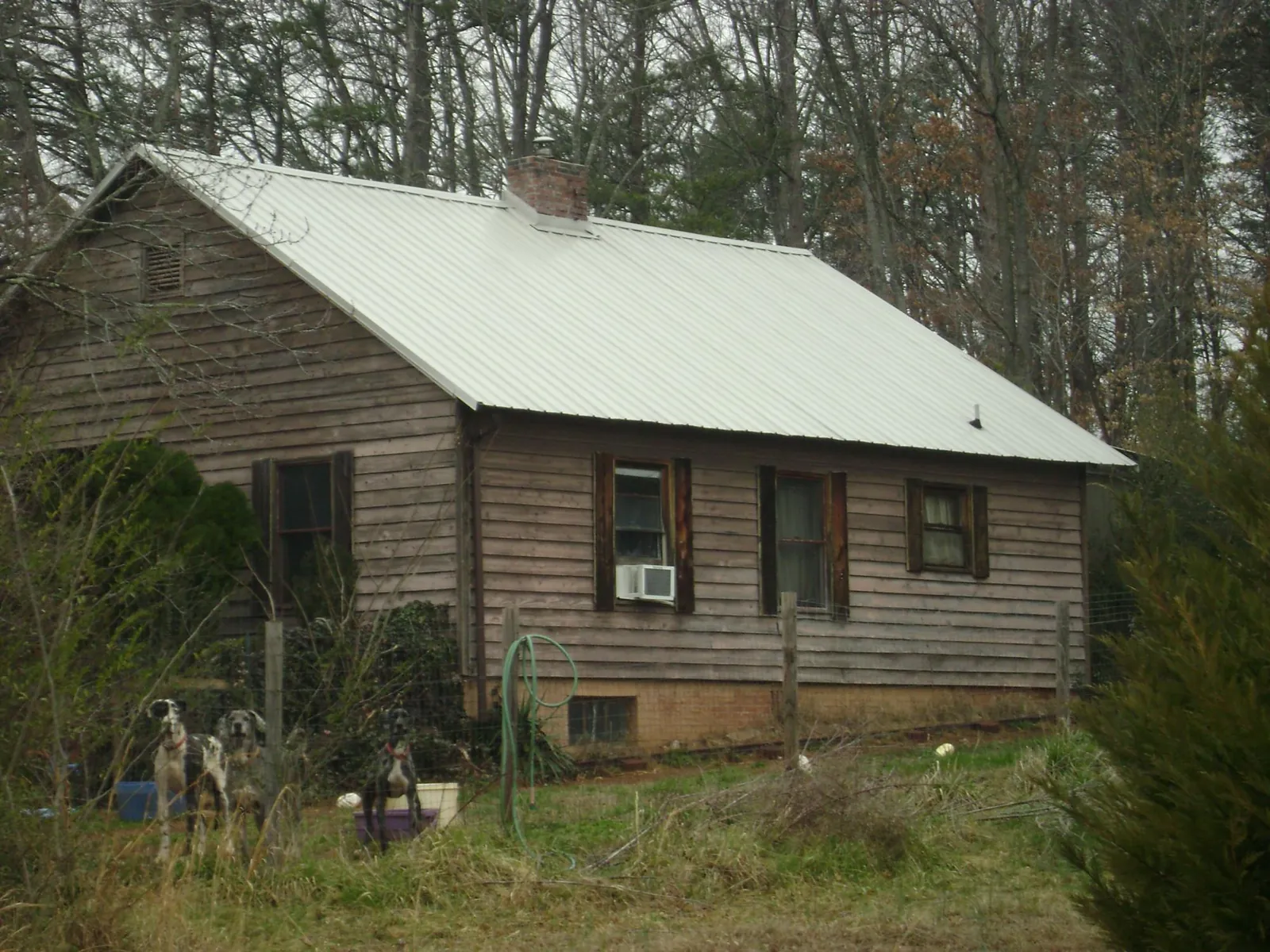 White metal roof on an old wood sided farmhouse, from a Metal Roof Installation job in Brown City